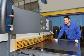 Максим Адяев у гидравлических ножниц с ЧПУ в цехе №57. Фото Елены Галкиной