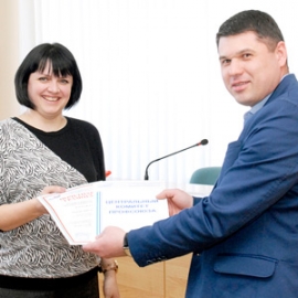 Председатель профкома АПЗ Александр Тюрин вручает Ирине Ушаковой грамоты обкома и ЦК Профавиа. Фото: Елена Галкина