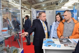 Директор по производству и продажам гражданской продукции Владислав Цыцулин с посетителями стенда АО «АПЗ». Автор фото: Александр Барыкин