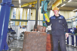 Иван Гаранин, слесарь-инструментальщик, аттестованный на работы с грузоподъёмными механизмами, управляемыми с пола, проводит статическое испытание крана. Фото Елены Галкиной