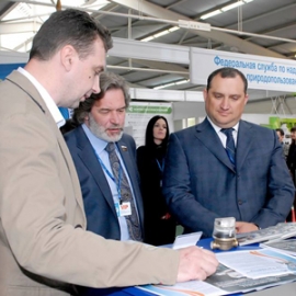 Начальник отдела маркетинга Михаил Сурнин (слева) презентует счётчик с радиомодулем «Стриж» почётным гостям форума: заместителю председателя Законодательного Собрания Нижегородской области Александру Табачникову и заместителю губернатора Нижегородской области Александру Байеру