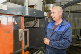 Наладчик машин и автоматических линий по производству изделий из пластмасс цеха №31 Игорь Логинов вынимает готовый лоток из загрузочного бункера термопластавтомата SP-400