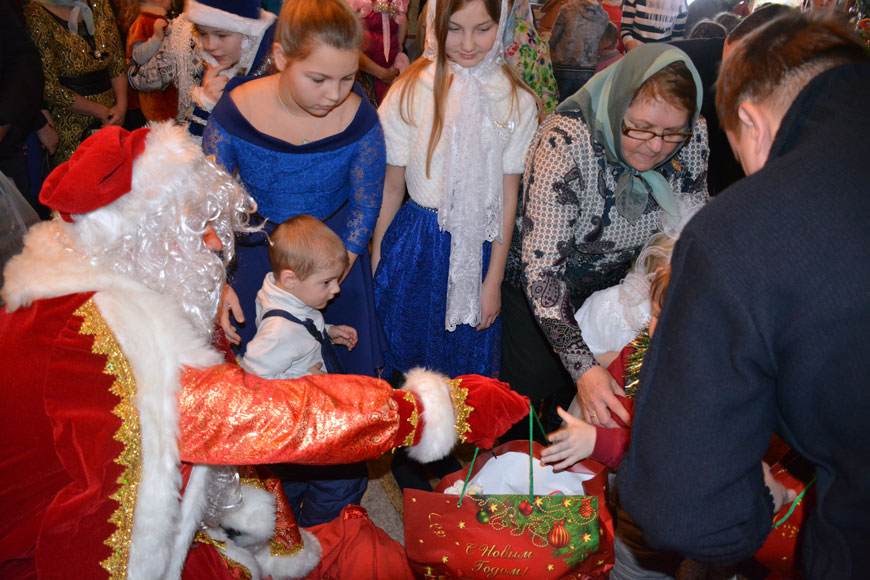 Дед Мороз раздает подарки на Рождественском утреннике для детей в храме Святого Иоанна 